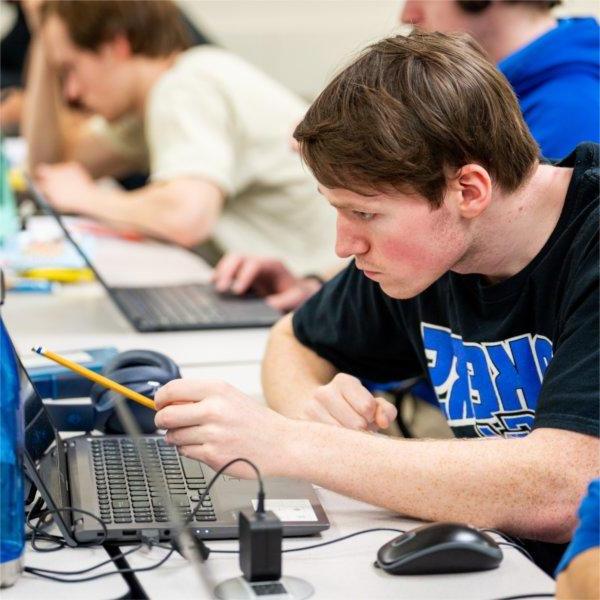 student points to laptop screen in computer lab