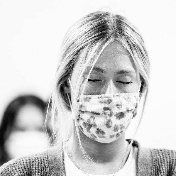 student in face mask with eyes closed during a mindfulness class